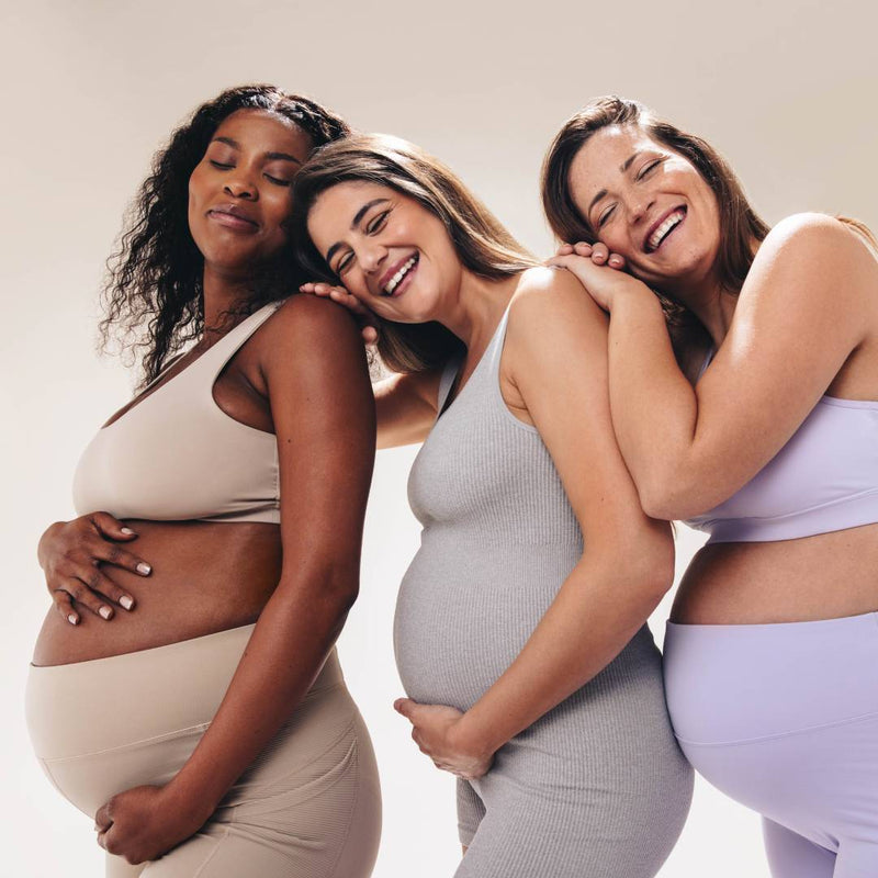 Group of three pregant mothers supporting one another