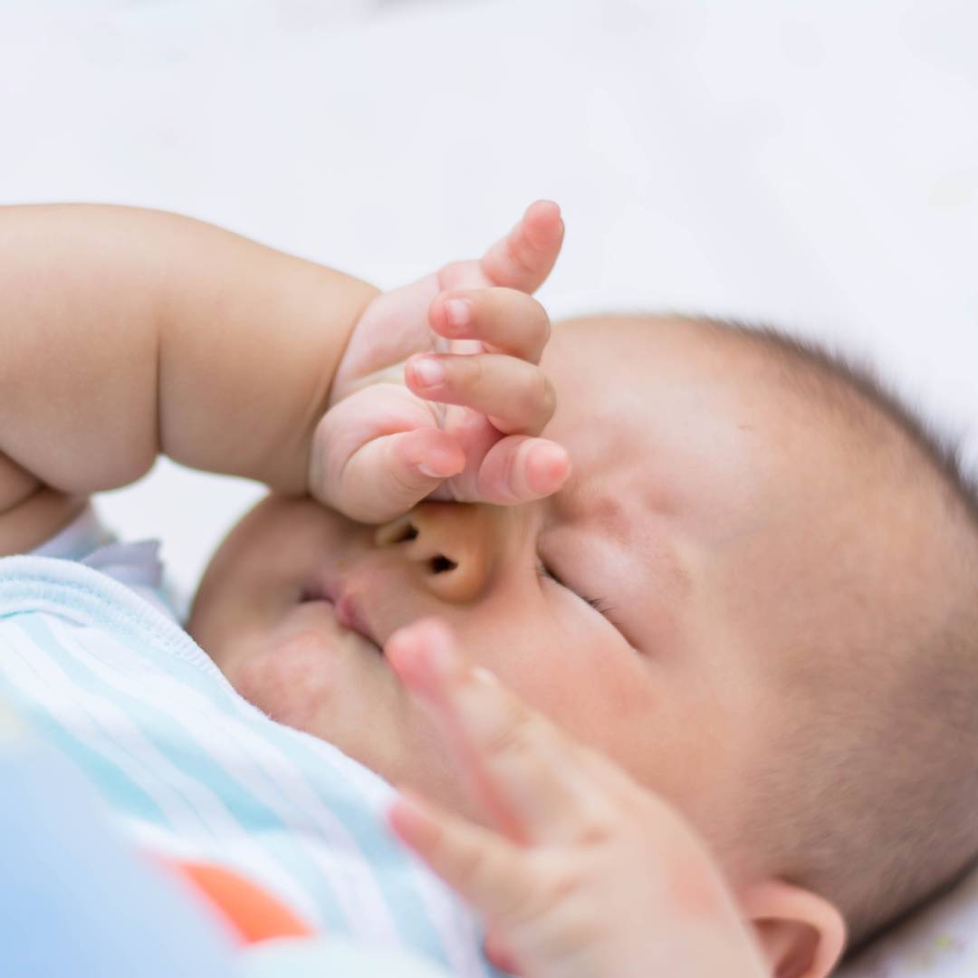 Baby showing they are sleepy by rubbing their eyes